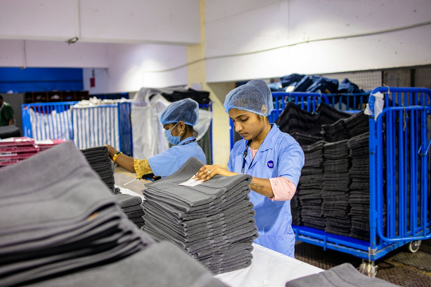 Workers folding and sorting garments at a processing table