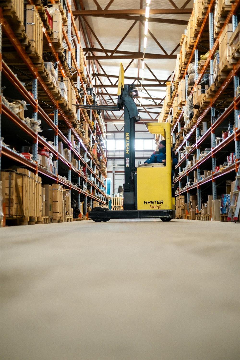 Forklift moving inbound stock in a warehouse aisle