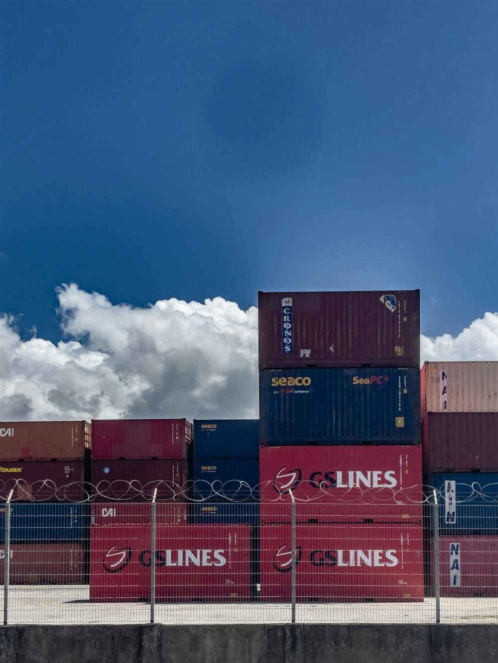 Colorful shipping containers stacked under a blue sky